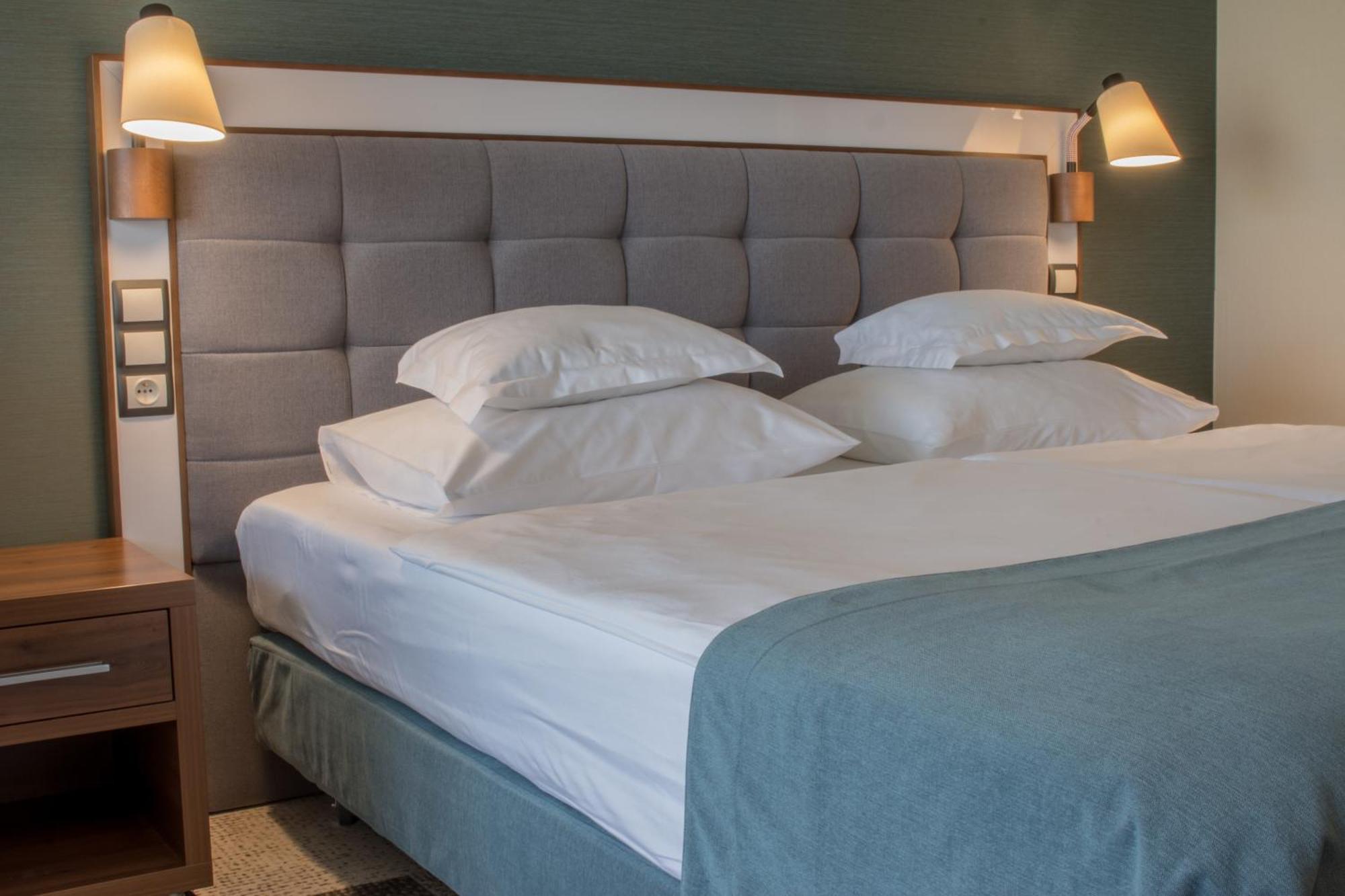 Hotel Aquarius Spa Колобжег Екстериор снимка A bed with a headboard